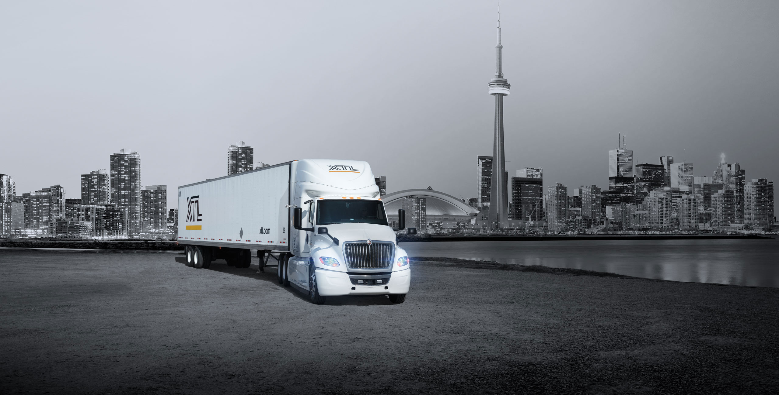 XTL transport truck parked, with city of Toronto in the background
