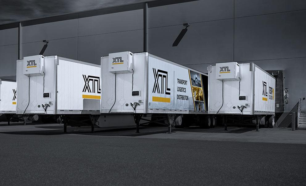 Multiple XTL heated trailers backed into a crossdocking, warehouse facility