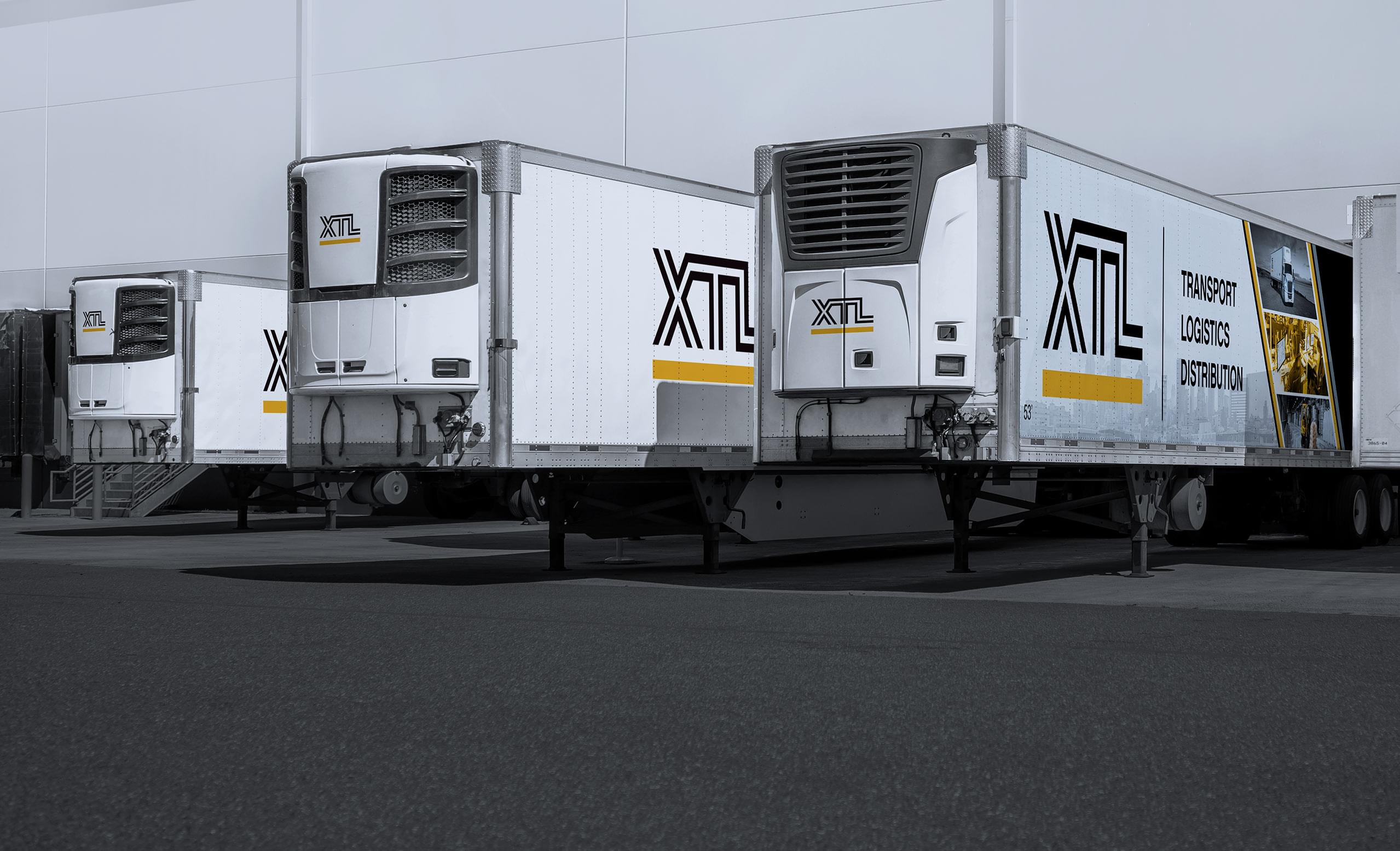 Multiple XTL refrigerated trailers backed into a crossdocking, warehouse facility