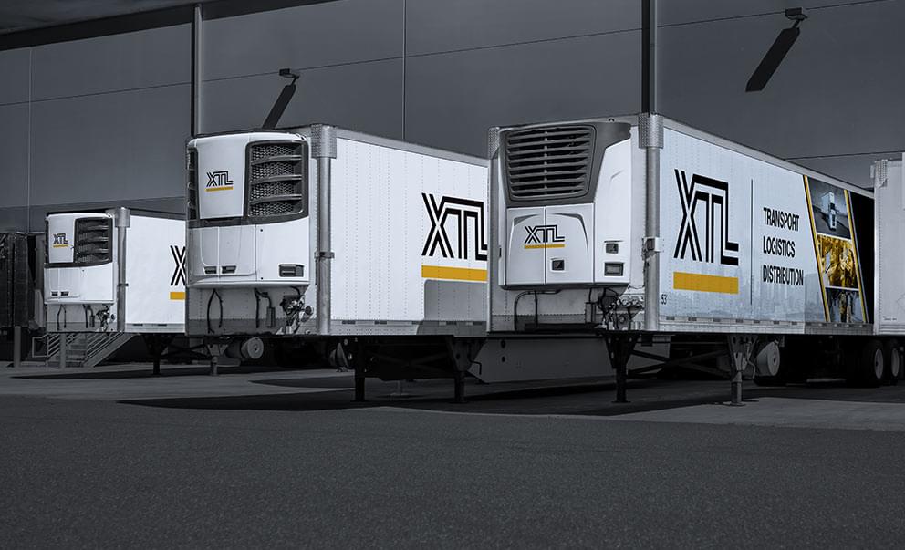 Multiple XTL refrigerated trailers backed into a crossdocking, warehouse facility